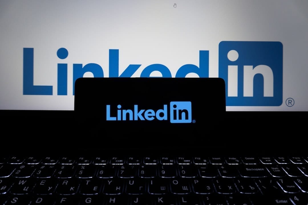 Professional scheduling LinkedIn posts from a laptop in a home office