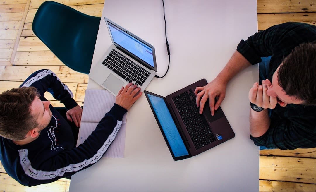 Agency team in a meeting reviewing client onboarding documents on laptops